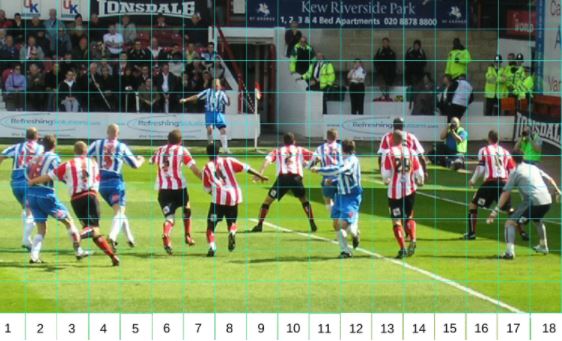 Two teams playing football with crowd in background