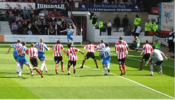 two teams play football with crowd in background